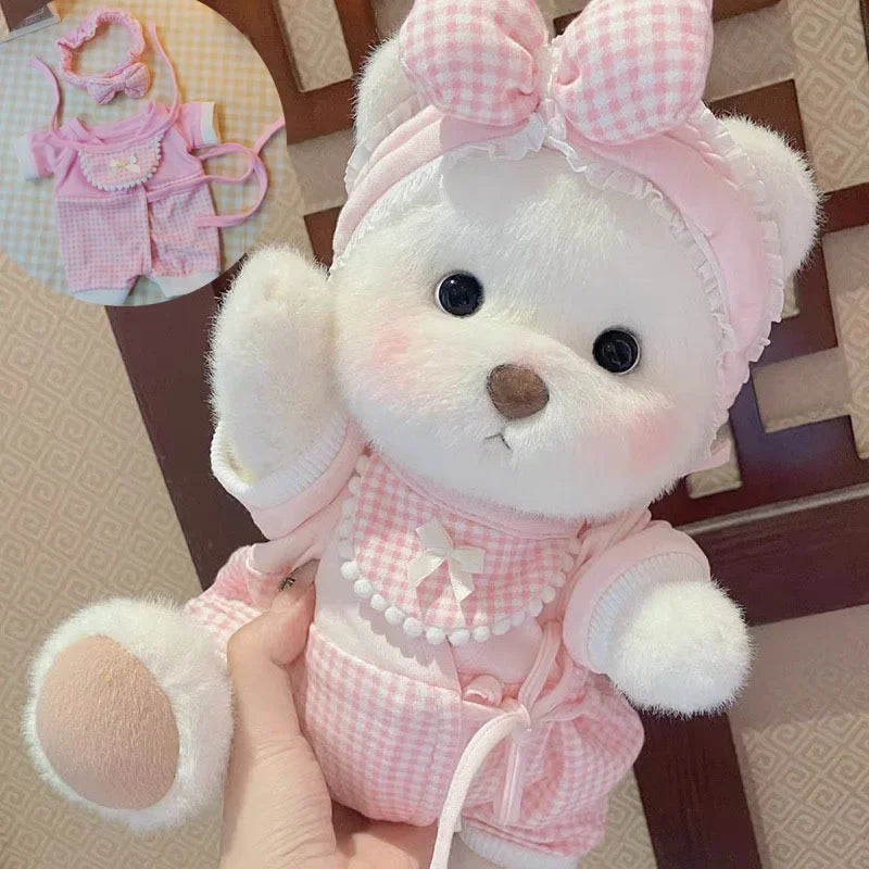 A white teddy bear plush wearing a pink checkered dress and bow, held in a hand.