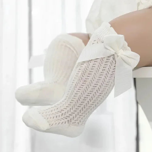 White lace knee socks for a baby girl with a decorative bow