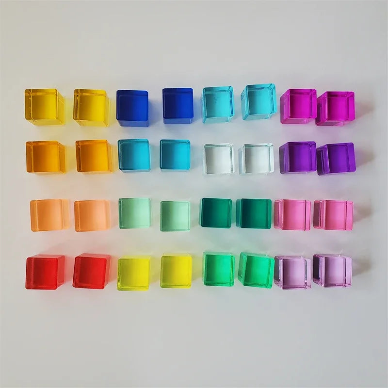 A row of colorful acrylic building blocks in various shades including yellow, orange, blue, green, and pink.