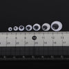 A row of clear, self-adhesive moving eyes of various sizes placed on a ruler for scale.