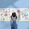 A child is drawing on a large sheet of white paper with various doodles and icons.