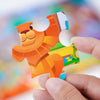 A hand holds an orange animal cartoon jigsaw puzzle piece shaped like a lion, featuring bright colors and playful design.