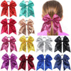 A collection of twelve glitter sequin hair bows in various colors and patterns for girls
