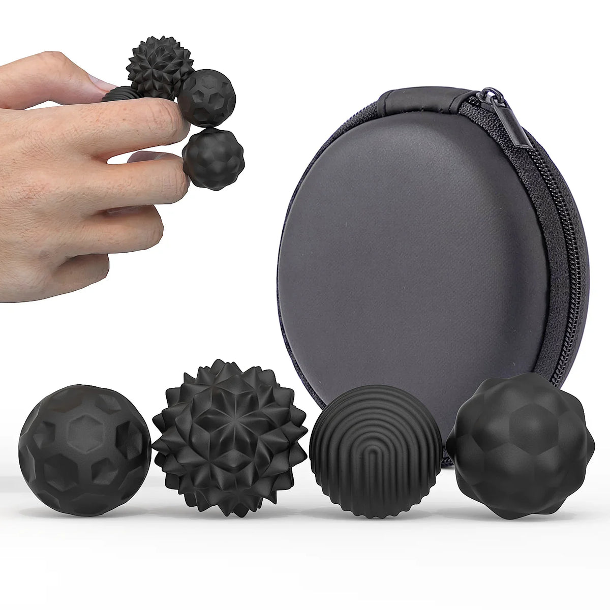 Black soft sensory silicone massage balls with magnetic cores shown next to a hand and a zippered pouch.