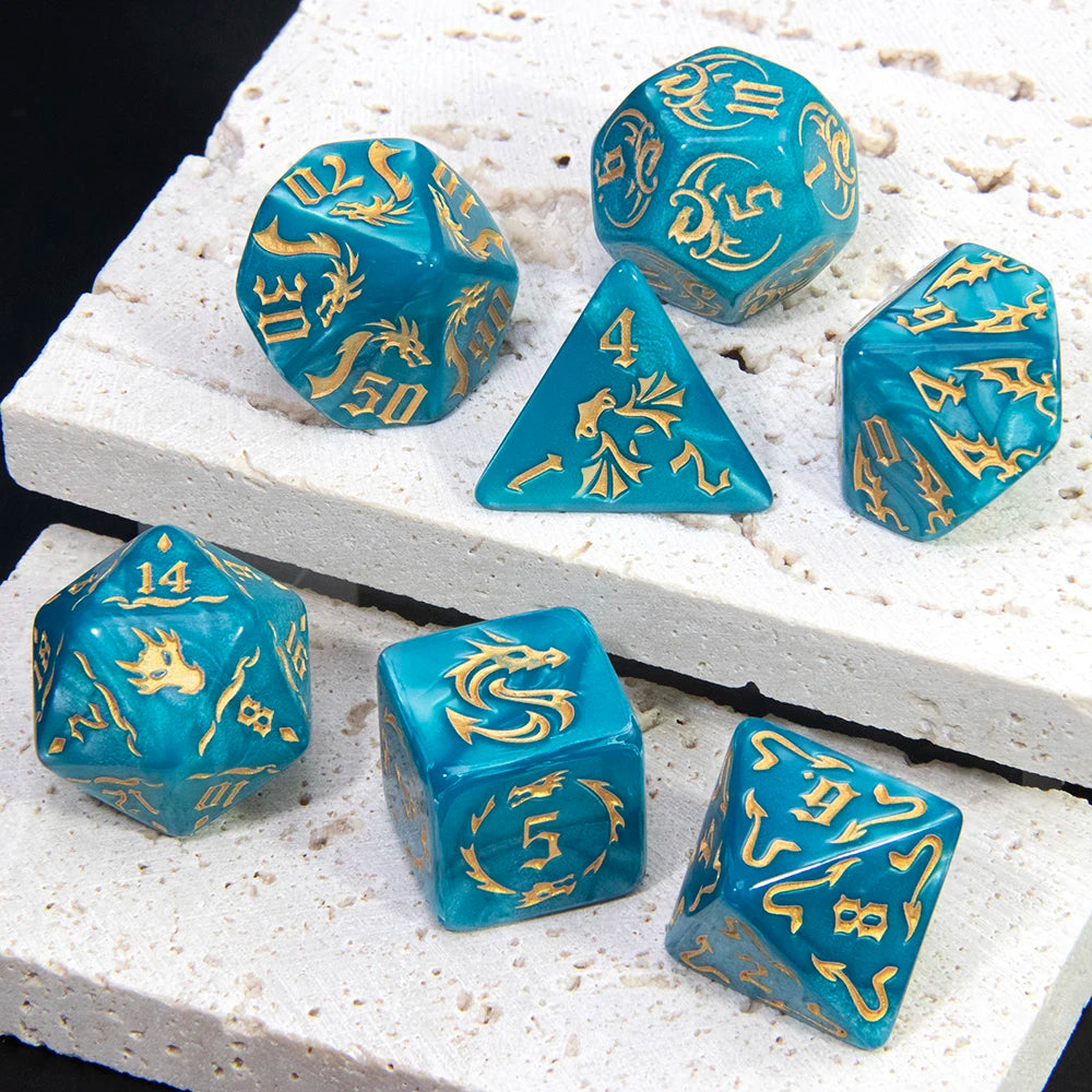 A set of marble dragon pattern polyhedral dice in various sizes and shades of blue and teal resting on a white surface.