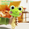 A hand is holding a green sand hammer baby toy with a crown on its head