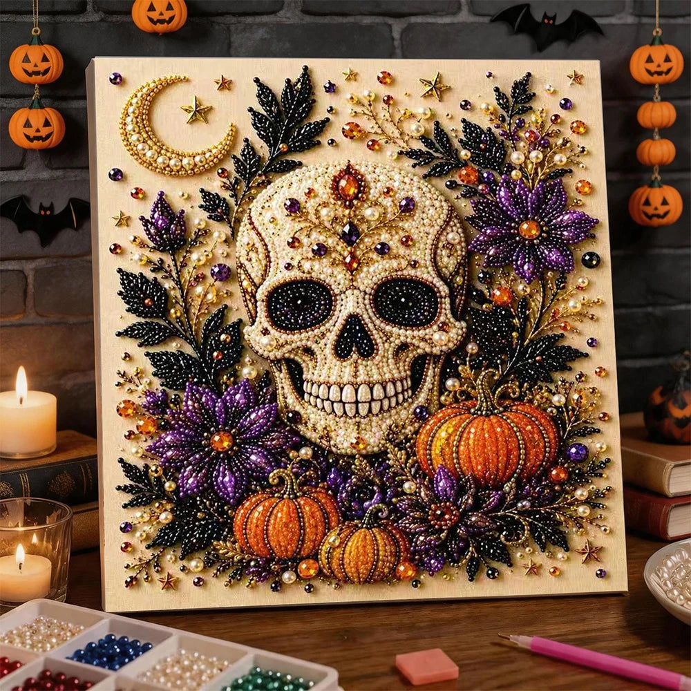 A framed piece of art featuring a skull and pumpkin design made with 3D pearls and foliage for a Halloween theme.