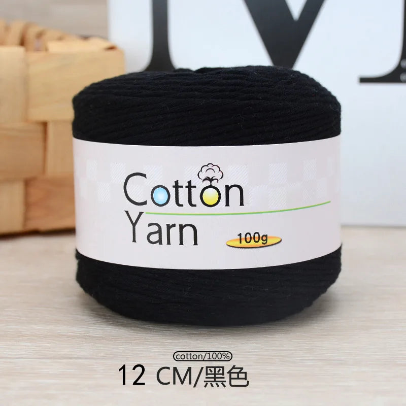 A ball of black 100% cotton yarn labeled for knitting and crochet projects.
