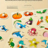 A wooden shape matching puzzle board featuring various fruits, animals, and sea creatures for bilingual early learning.