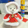 A white plush teddy bear wearing a red and gold dress with a white fur hood.
