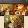 A detailed wooden dollhouse kit of a pink princess villa with interior furnishings and LED lights.
