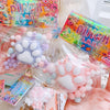 A collection of pink and purple cat paw squishy stress relief toys packaged in clear plastic bags.