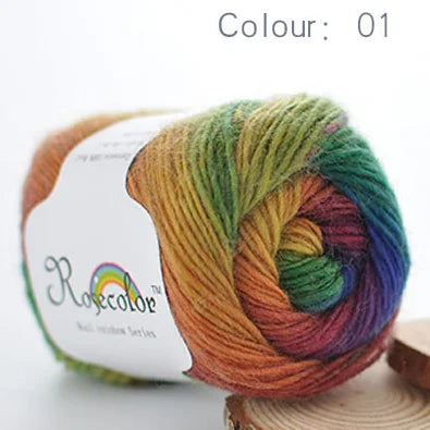 A ball of hand-dyed rainbow merino wool yarn, color 01, shown on a wooden surface.