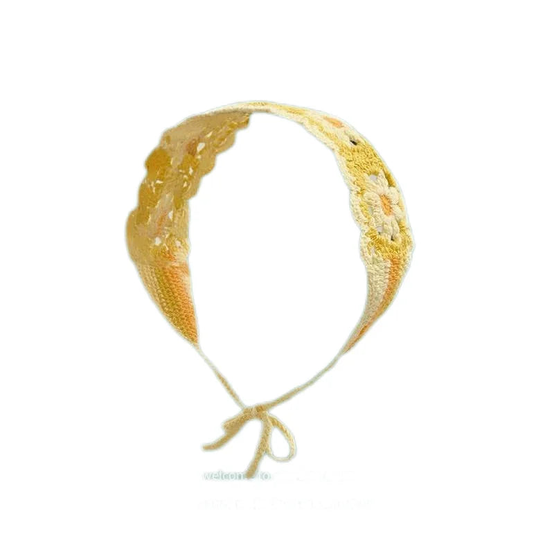 A yellow strawberry crochet headband with a wide elastic band.