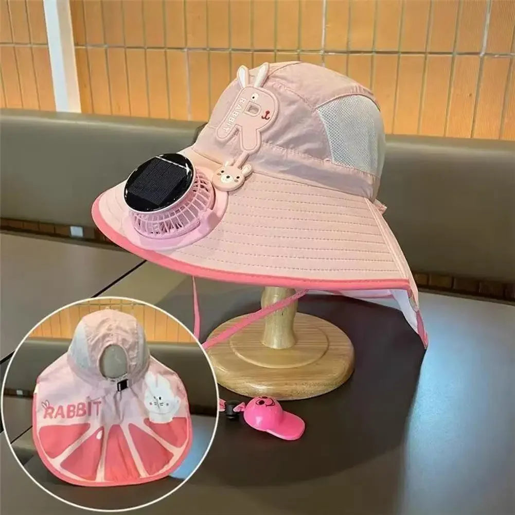 Pink sun hat with a mesh back and a solar-powered cooling fan attached, resting on a wooden surface.