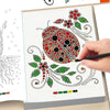 A hand is coloring a page of dot art with a black pencil, showing various colored dots on a white background.