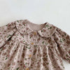 A light pink floral print baby girl jumpsuit with a doll collar and long sleeves.