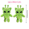 A pair of green alien cat plush toys with black eyes and pointed ears.