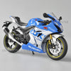Blue and white Suzuki GSX-R1000R diecast motorcycle model in a studio setting.