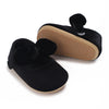Black lace-trimmed baby girl moccasin shoes with a bow shown from the side.