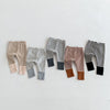 A collection of striped baby leggings in various colors and patterns laid out horizontally.