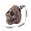 A ceramic Aztec skull whistle with a textured, earthy brown finish and a black mouthpiece.