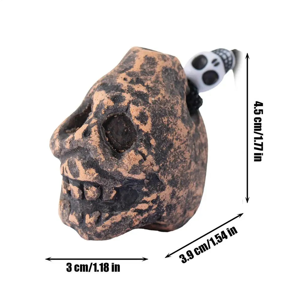 A ceramic Aztec skull whistle with a textured, earthy brown finish and a black mouthpiece.