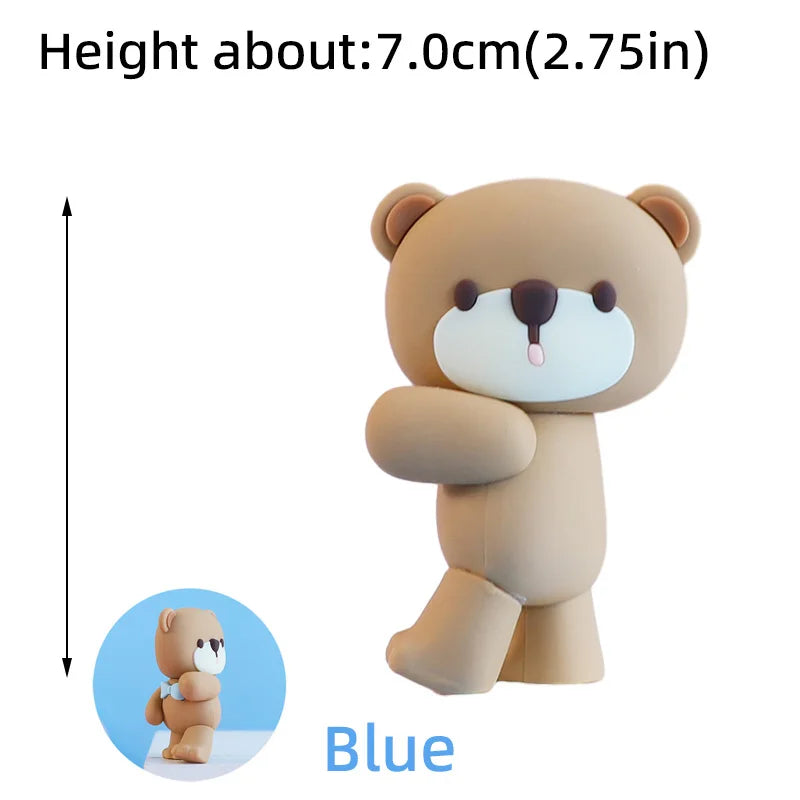 A light brown 3D bear cake topper with blue accents shown next to a scale.