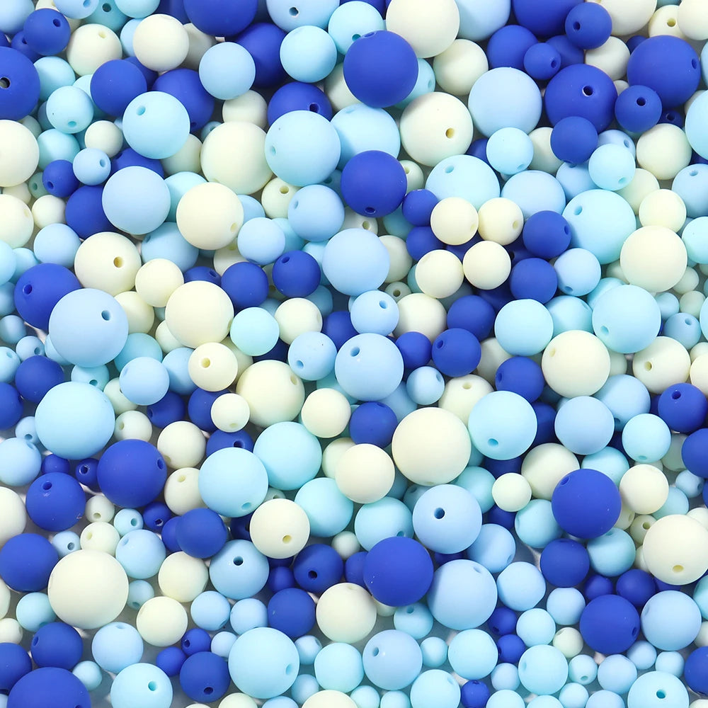 A close-up view of a variety of matte acrylic beads in shades of blue, white, and purple.