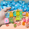 A hand holds a collection of glow-in-the-dark mini animal figures in various colors like yellow, green, and pink.