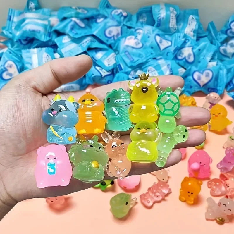 A hand holds a collection of glow-in-the-dark mini animal figures in various colors like yellow, green, and pink.