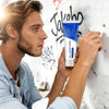 A man applies a tube of white wall repair paste to a white brick wall with visible graffiti.