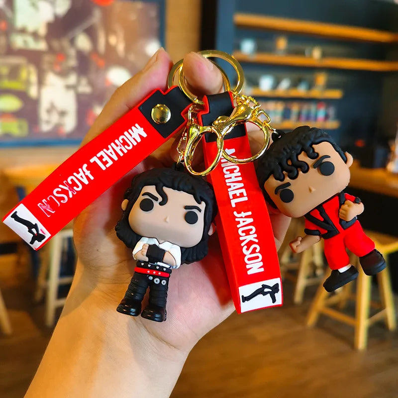 A hand holds a Michael Jackson Dance Pose keychain with a gold split ring and red tag.