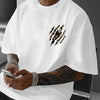 A man wearing a white Tiger Claw Never Give Up graphic cotton t-shirt, showing his arm tattoos.