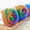 Spools of hand-dyed rainbow merino wool yarn for knitting and crochet
