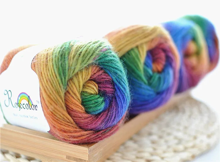 Spools of hand-dyed rainbow merino wool yarn for knitting and crochet