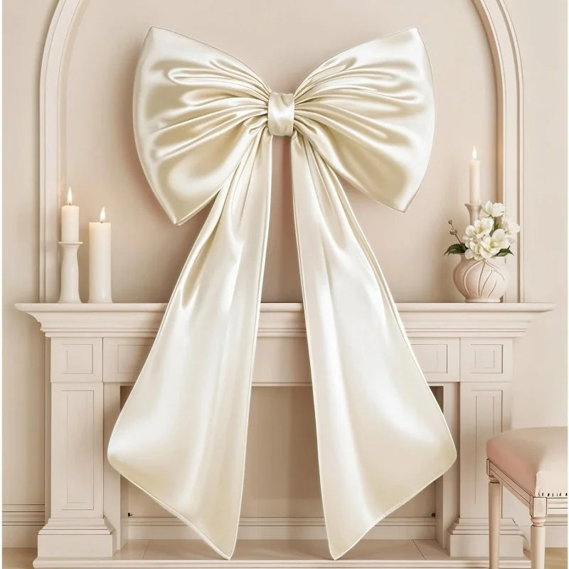 Oversized creamy white satin bow decoration displayed on a white mantelpiece