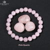 A bracelet made of round pink quartz beads encircling a larger central stone.