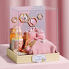 A clear acrylic display box featuring a miniature pink dollhouse with hexagonal window cutouts and soft pink bedding.