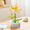 A set of rose flower building blocks featuring light pink petals and yellow centers, displayed on a wooden table.