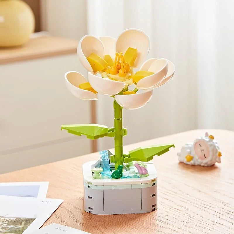 A set of rose flower building blocks featuring light pink petals and yellow centers, displayed on a wooden table.