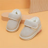 A pair of beige cozy leather winter boots for toddlers with a soft sherpa lining and anti-slip rubber sole.