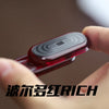 A hand holds a red electronic device with a black slider mechanism, used as an EDC fidget toy.