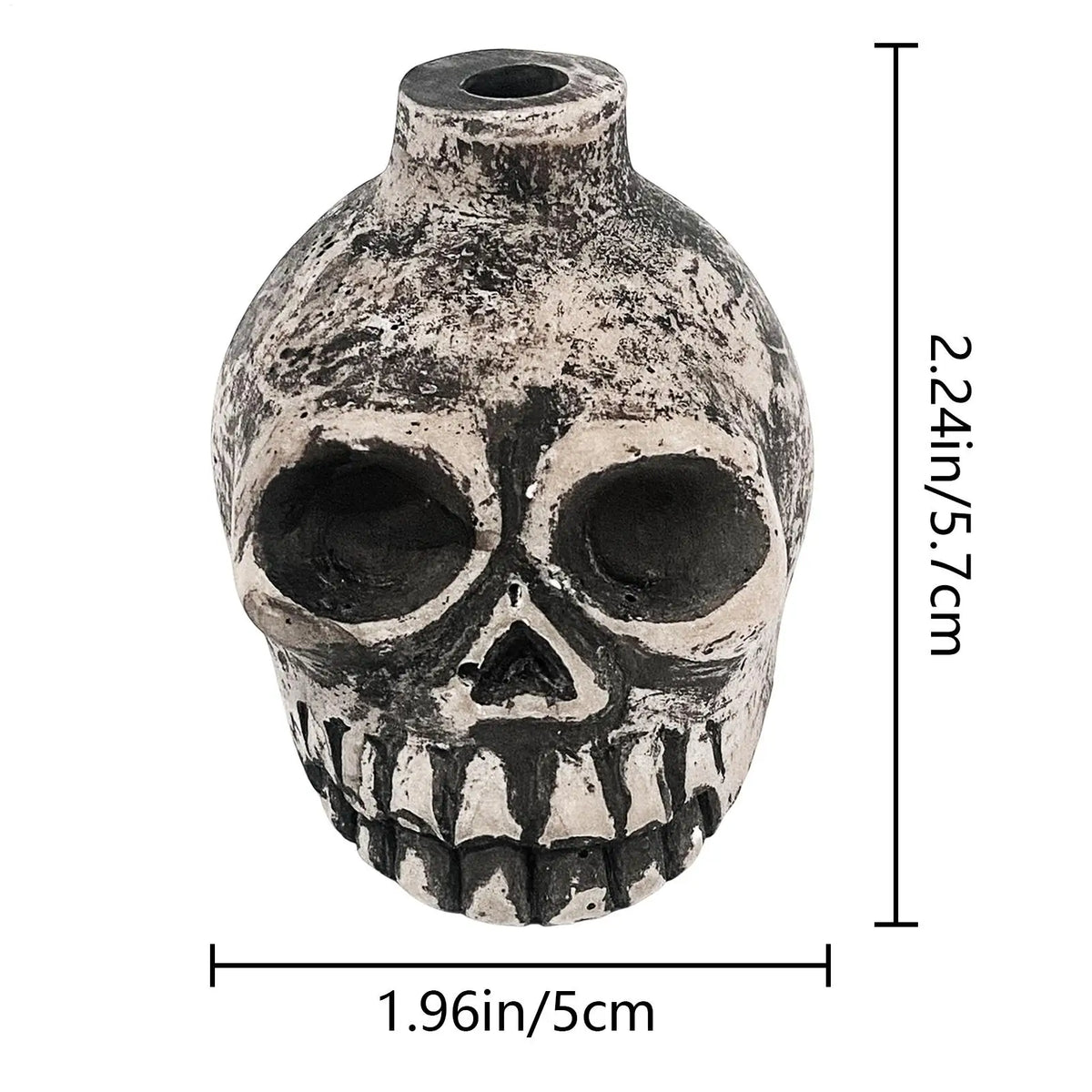 A weathered ceramic Aztec skull with a prominent nose and teeth, shown against a white background.