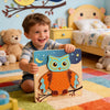 A child holds a wooden owl puzzle set featuring bright orange and blue colors on a colorful rug.