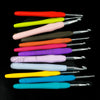 A collection of various colored crochet hooks and knitting needles arranged horizontally against a black background.