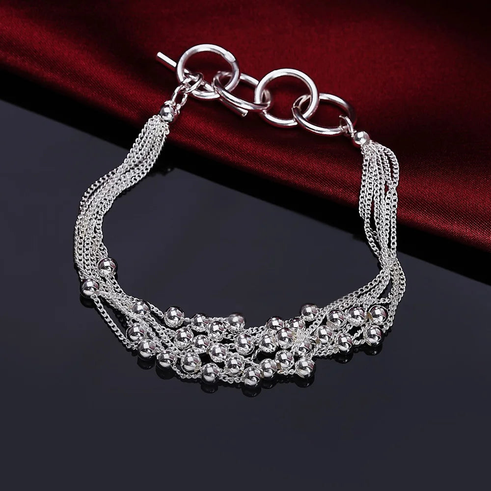 Elegant sterling silver snake chain bracelet for women displayed on a dark surface.
