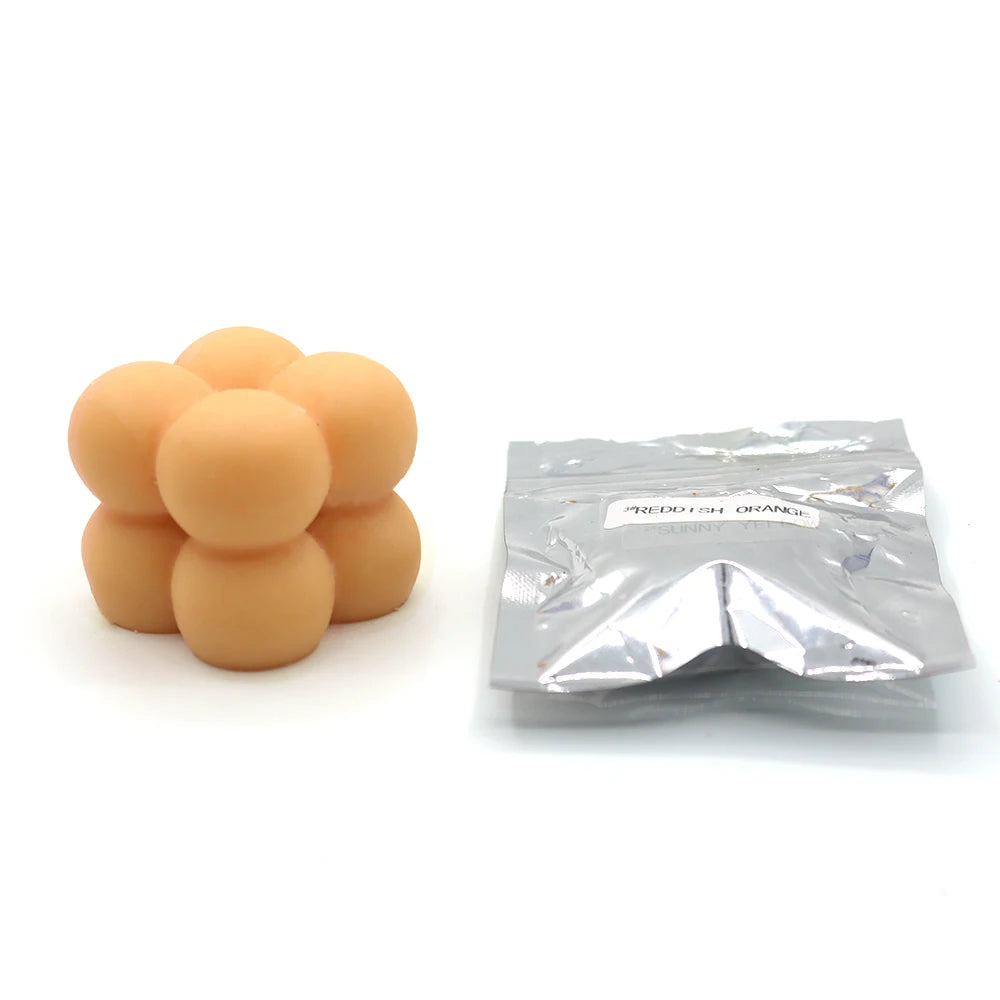 A pile of orange candle dye chips for soy wax, beeswax, and paraffin.