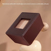 A dark brown wooden magic box puzzle with smooth edges is shown being held by a light-colored, rounded object.