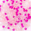 A pile of pink and magenta faceted crystal bicone glass beads for jewelry making.